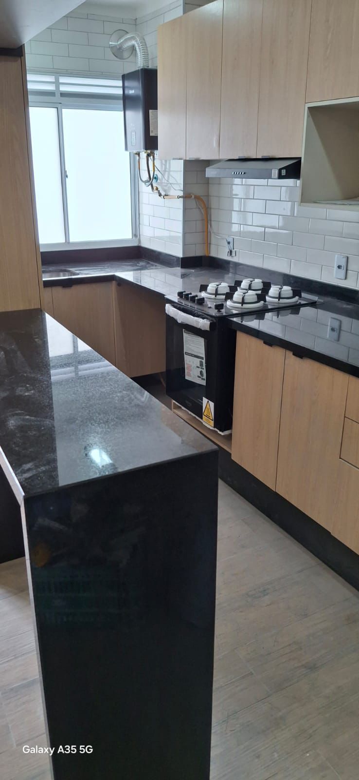 Cozinha com granito preto e marcenaria em madeira clara